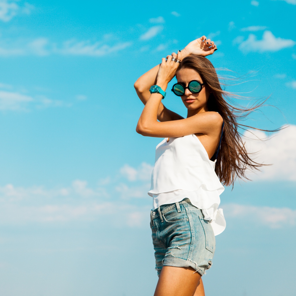 Красивая девушка в шортах на фоне неба