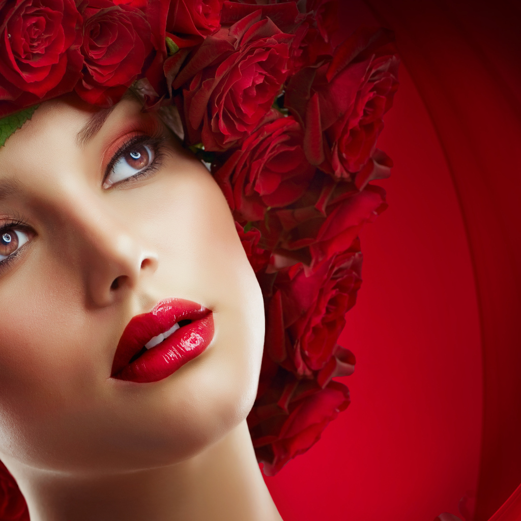 Красивая девушка с венком из роз на голове на красном фоне