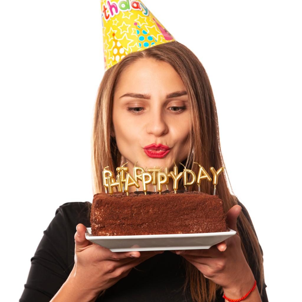 Красивая девушка с тортом на день рождения на белом фоне 