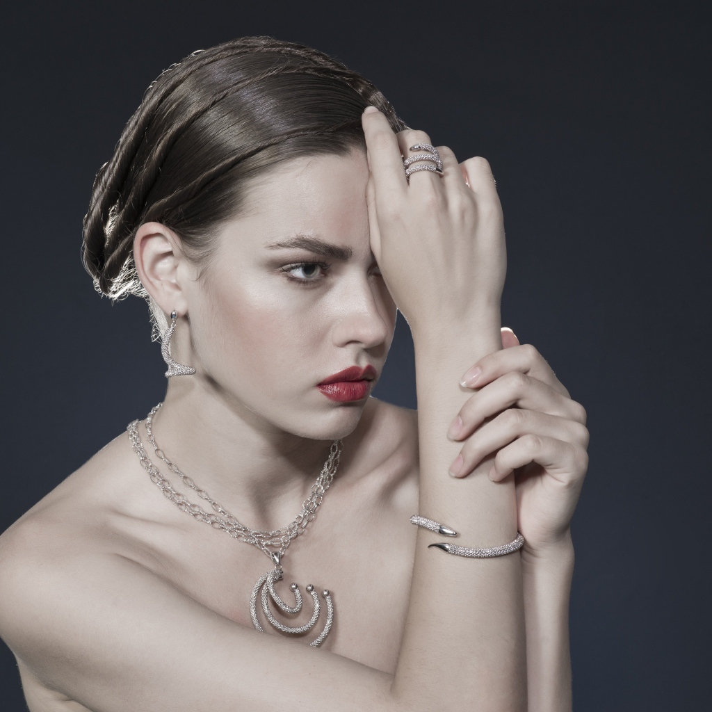 Красивая девушка с украшениями на теле на сером фоне