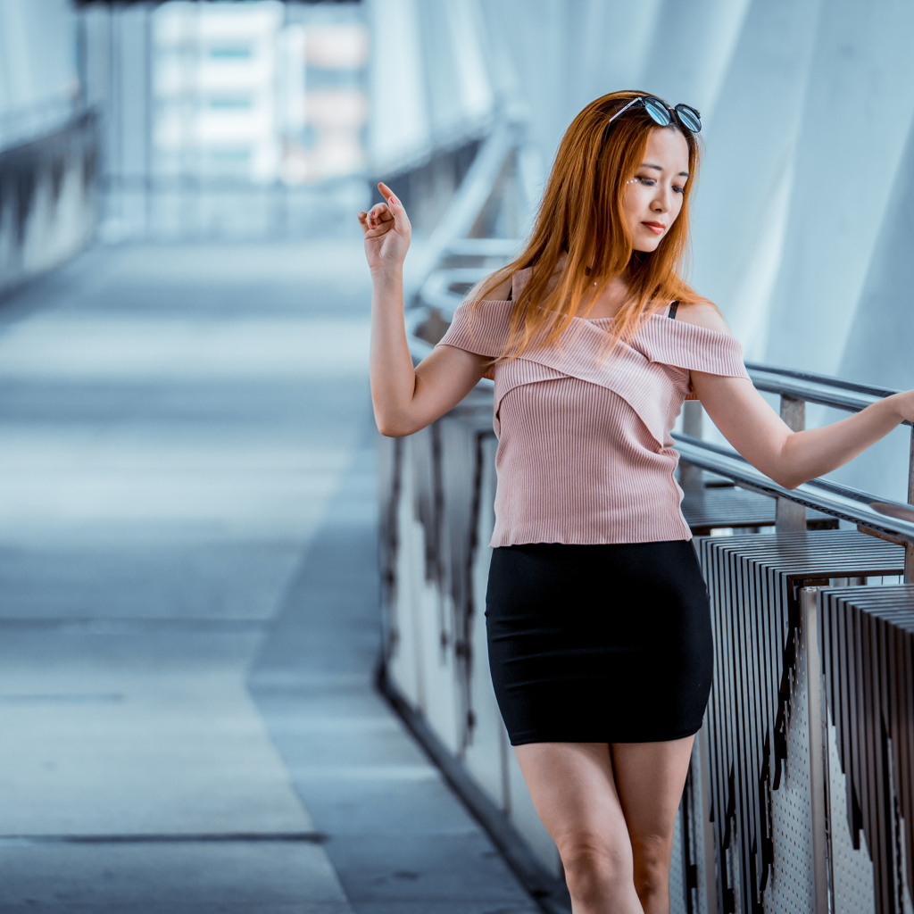 Красивая рыжеволосая девушка азиатка в черной юбке