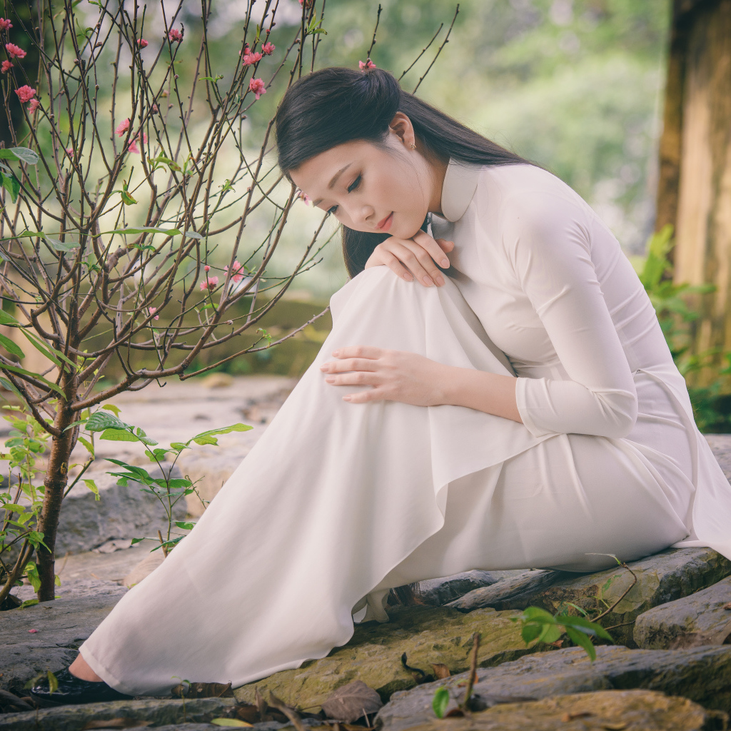 Красивая грустная девушка азиатка в белом платье 