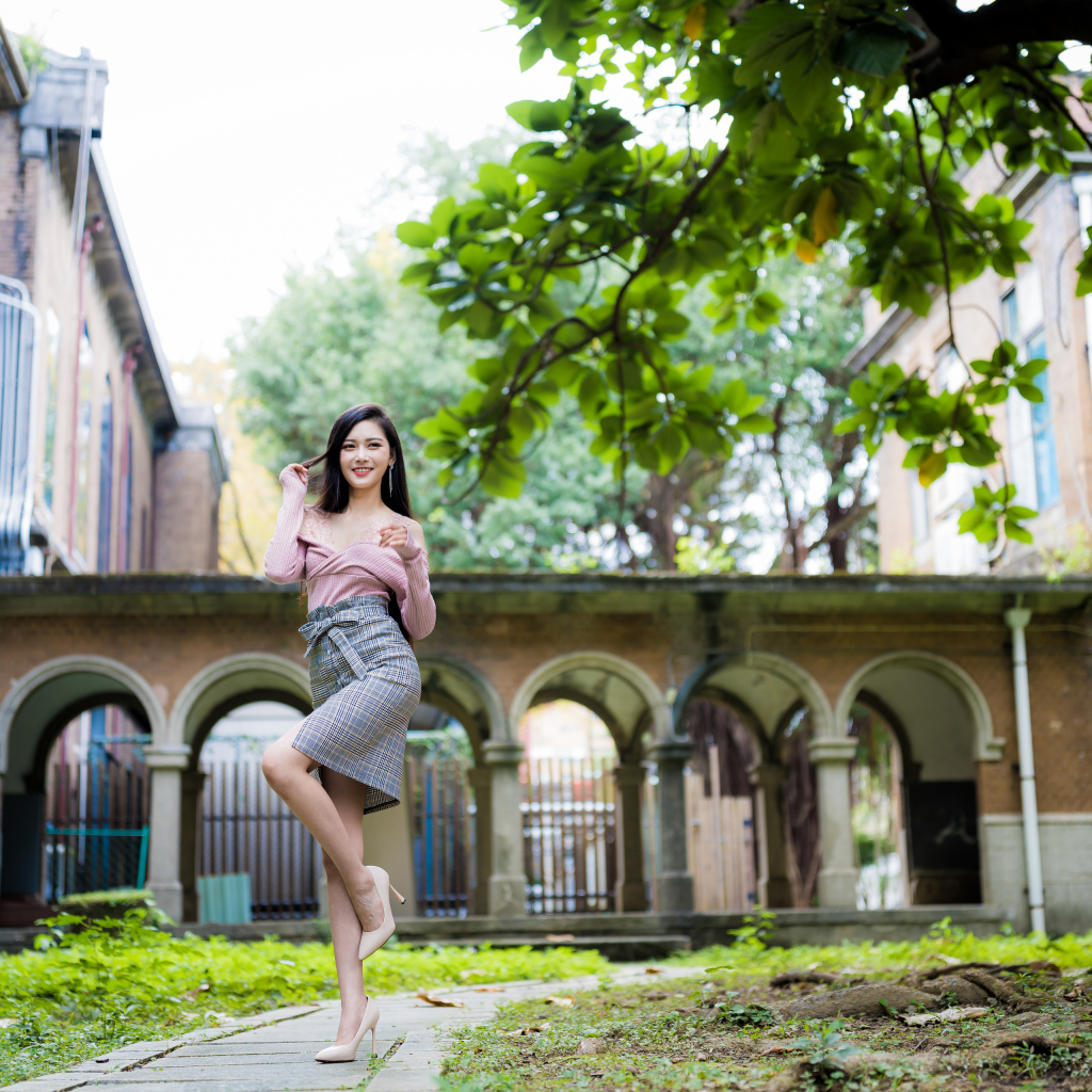 Красивая стройная азиатка на фоне здания