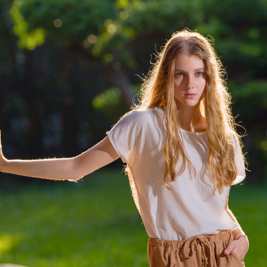 Красивая нежная девушка стоит у стены 