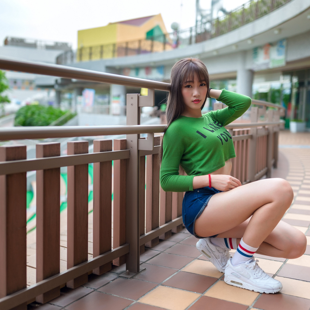 Красивая молодая азиатка в белых кроссовках 