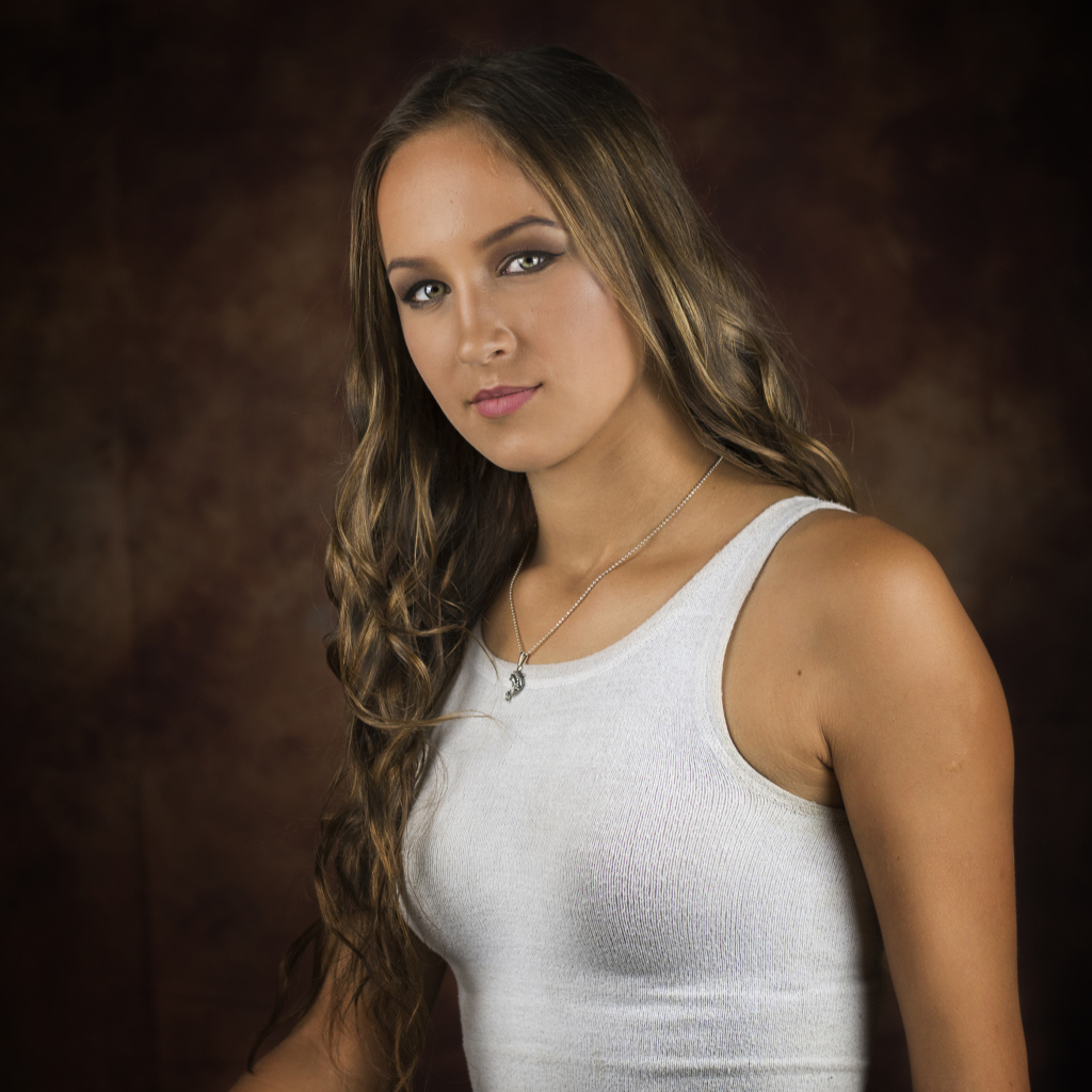 Красивая молодая девушка с длинными волосами в белой майке 