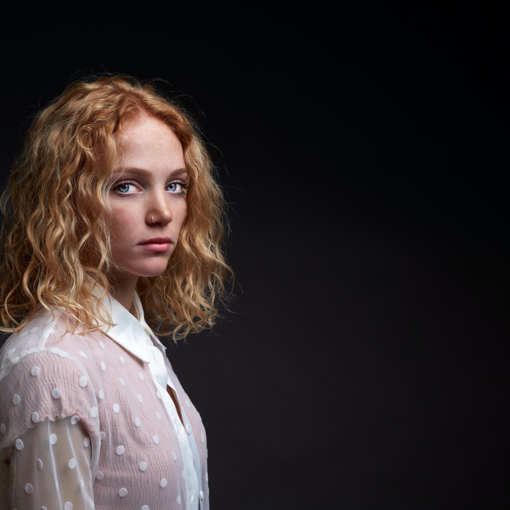 Голубоглазая девушка в белой рубашке на черном фоне