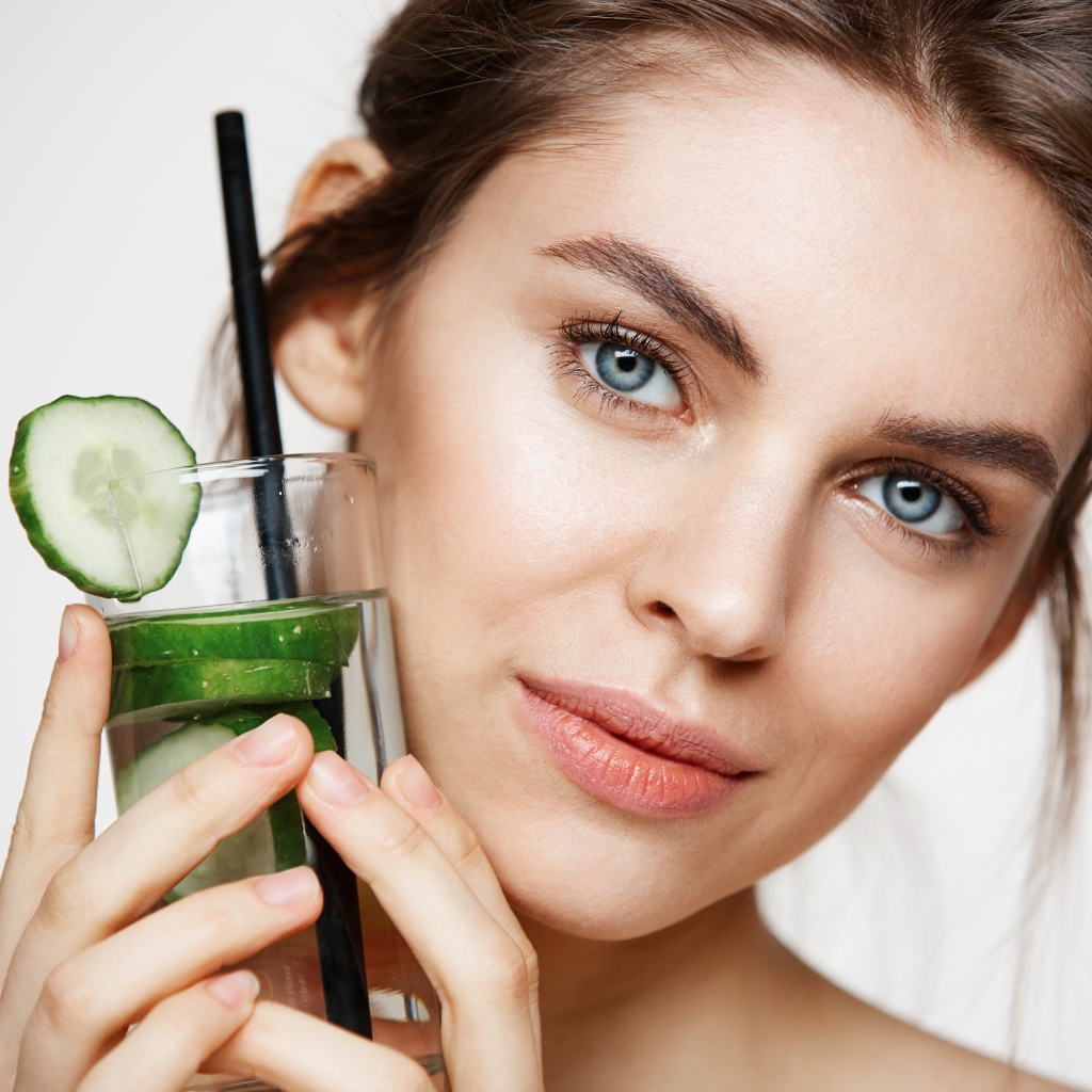 Голубоглазая девушка с огуречным напитком в руке 
