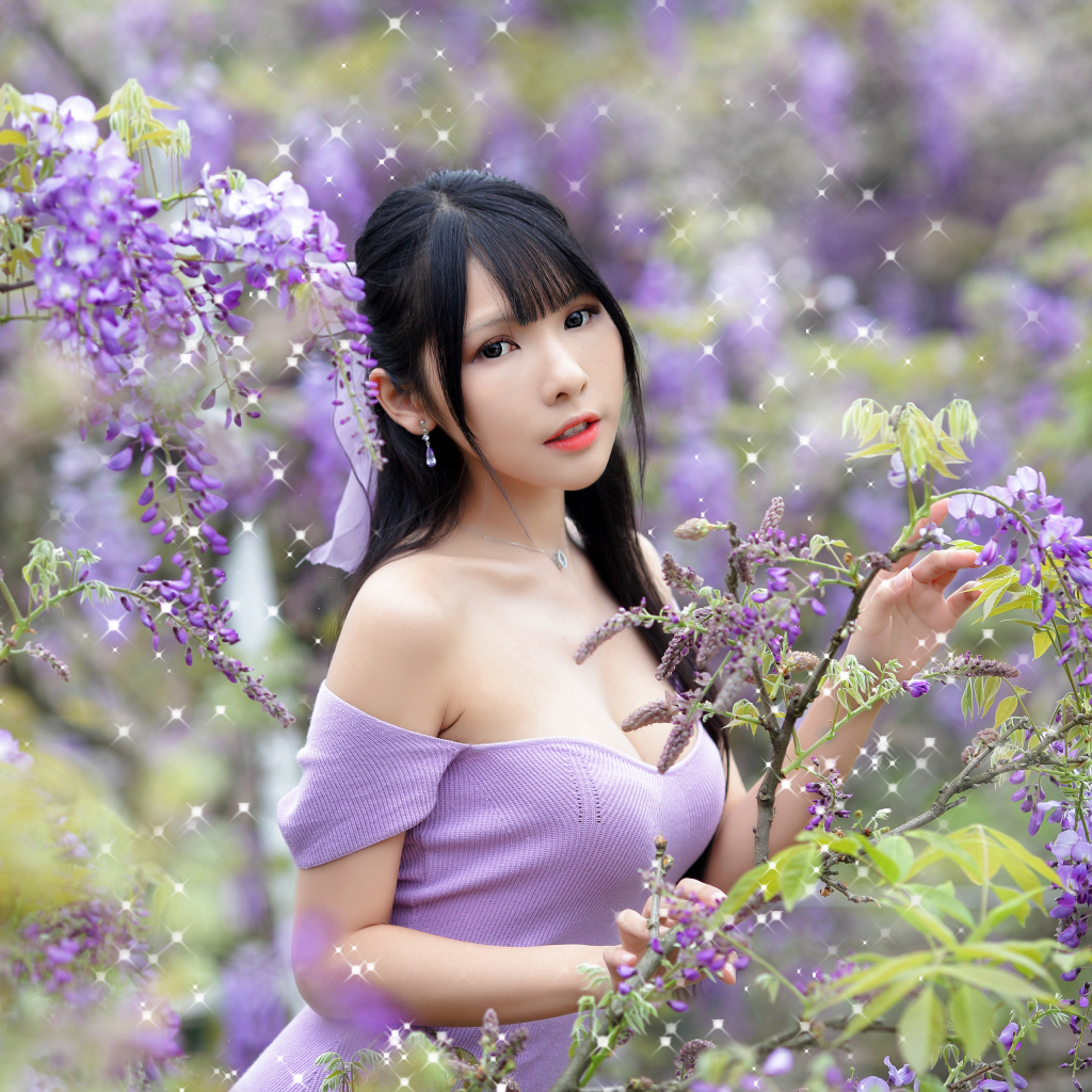 Кареглазая азиатка у куста с цветами глицинии