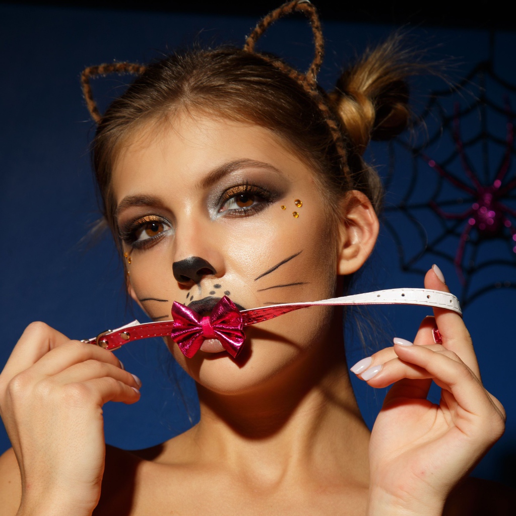 Девушка кошка с красным бантиком во рту 