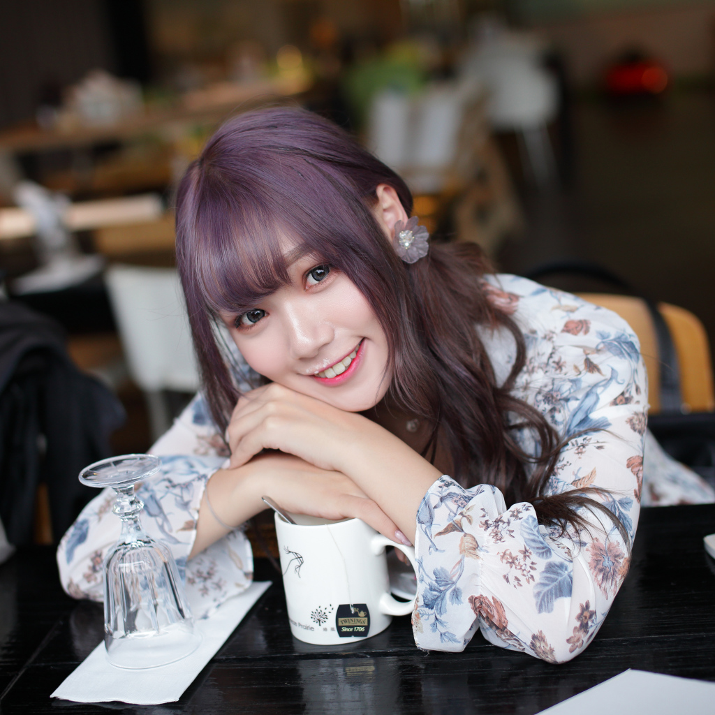 Милая девушка азиатка сидит за столиком