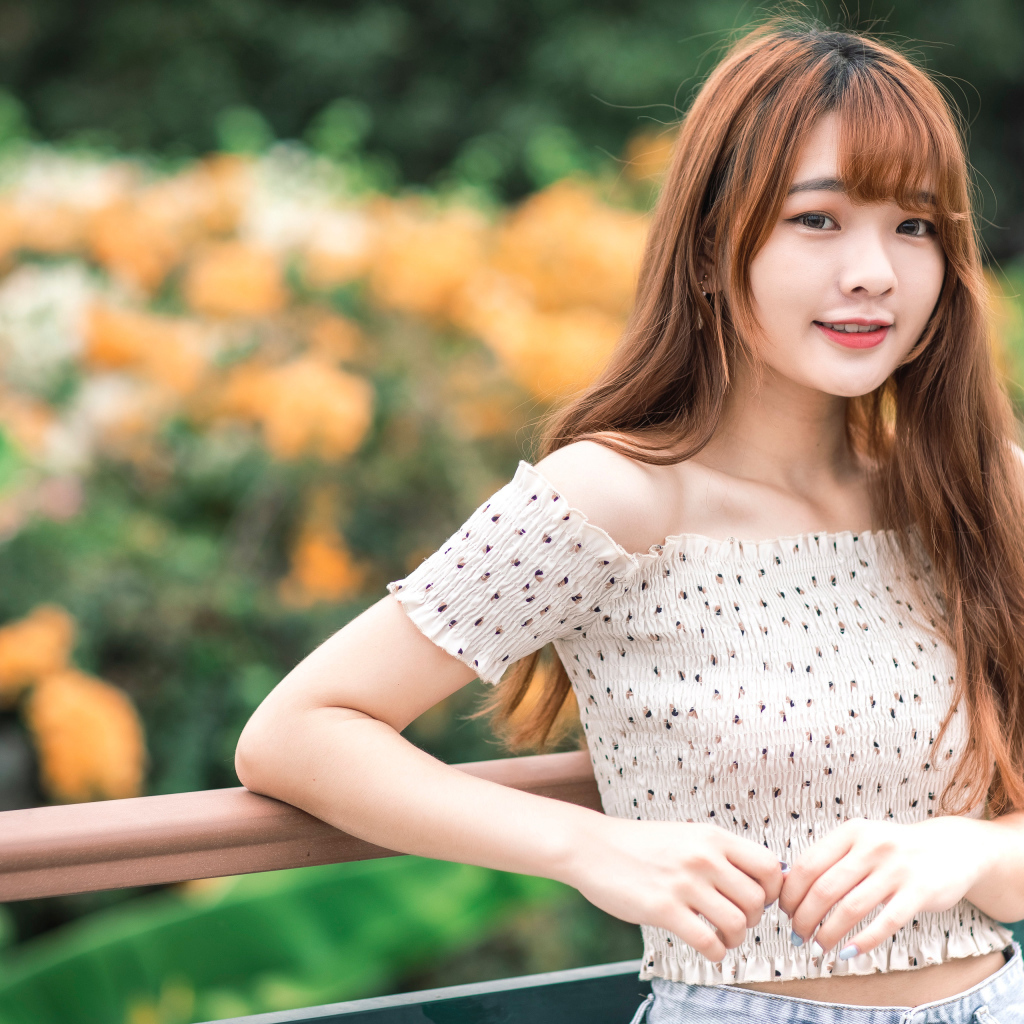 Милая девушка азиатка стоит у перил