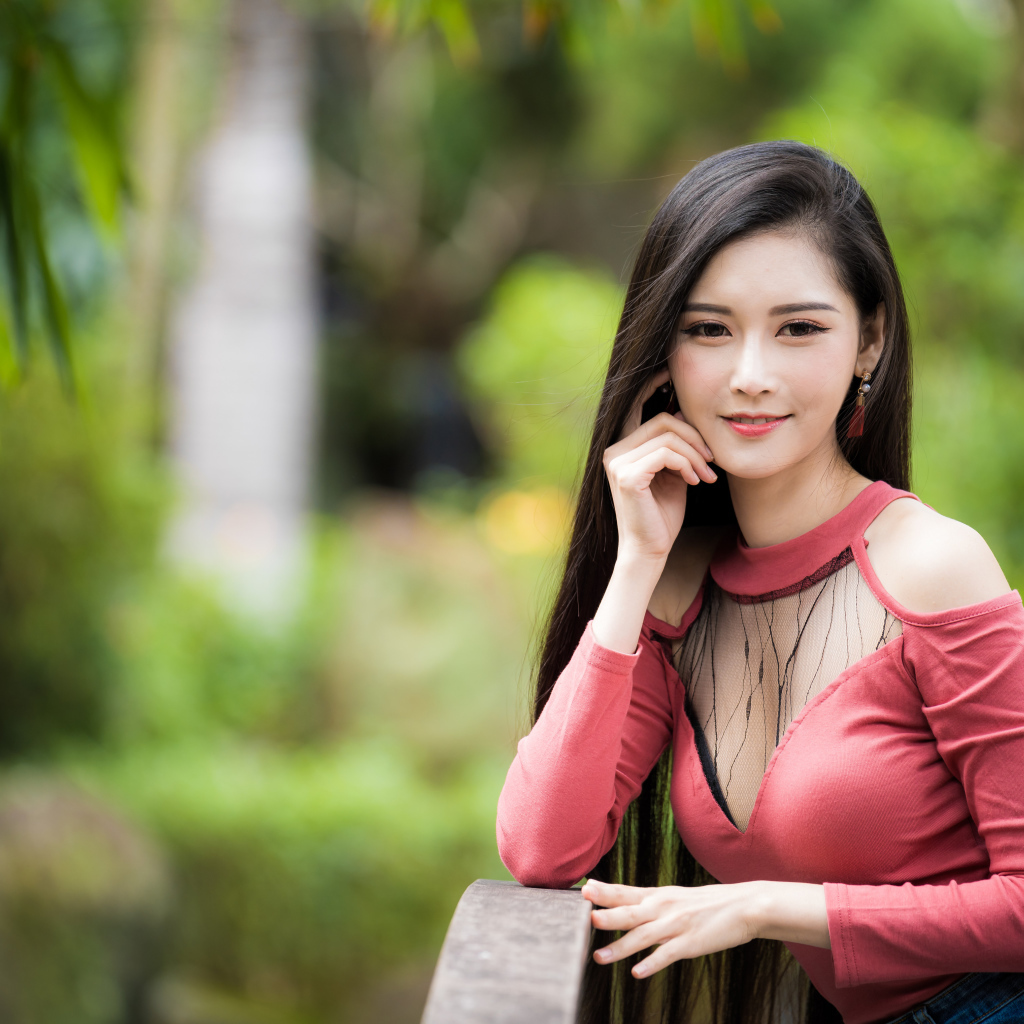 Милая улыбающаяся девушка азиатка розовой кофте