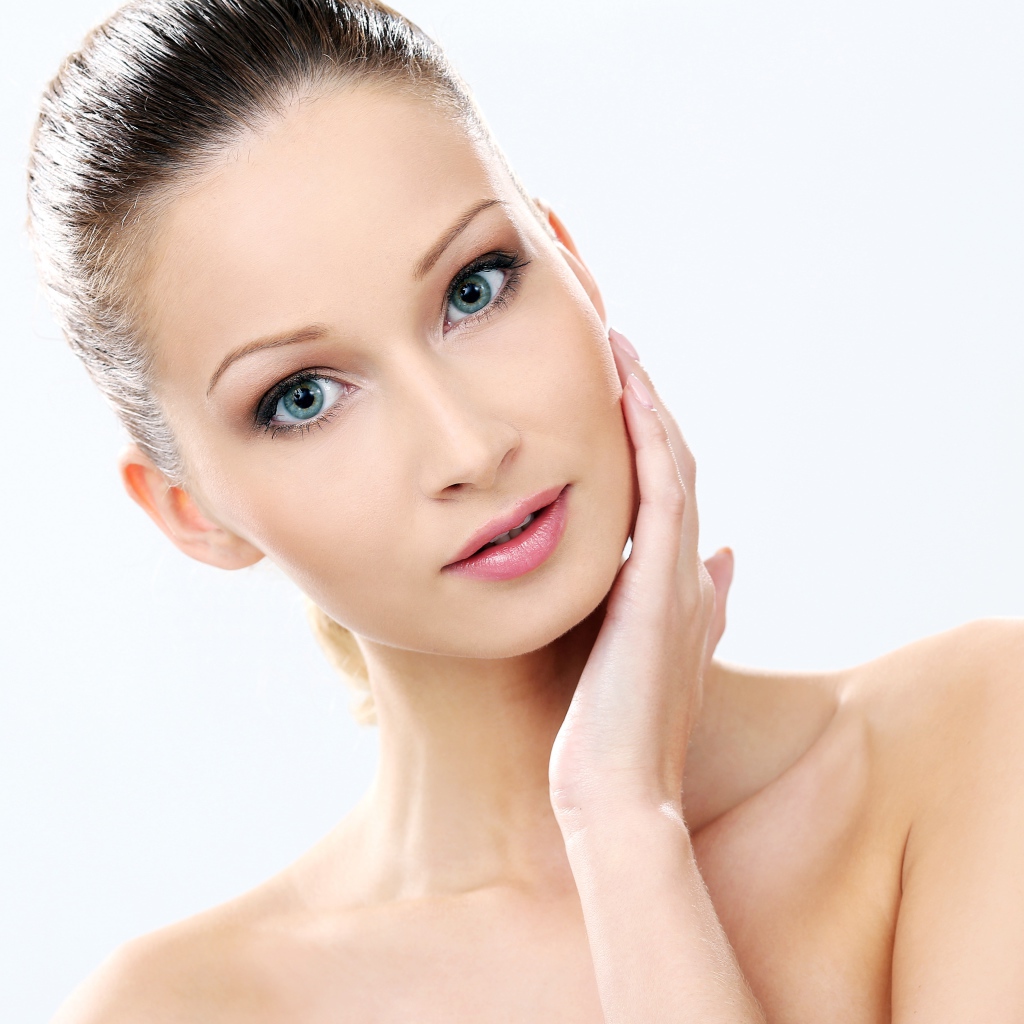 Нежная голубоглазая девушка без макияжа на белом фоне