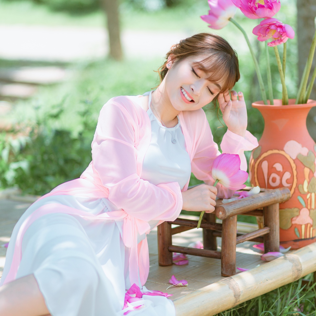 Мечтательная девушка азиатка с цветами лотоса