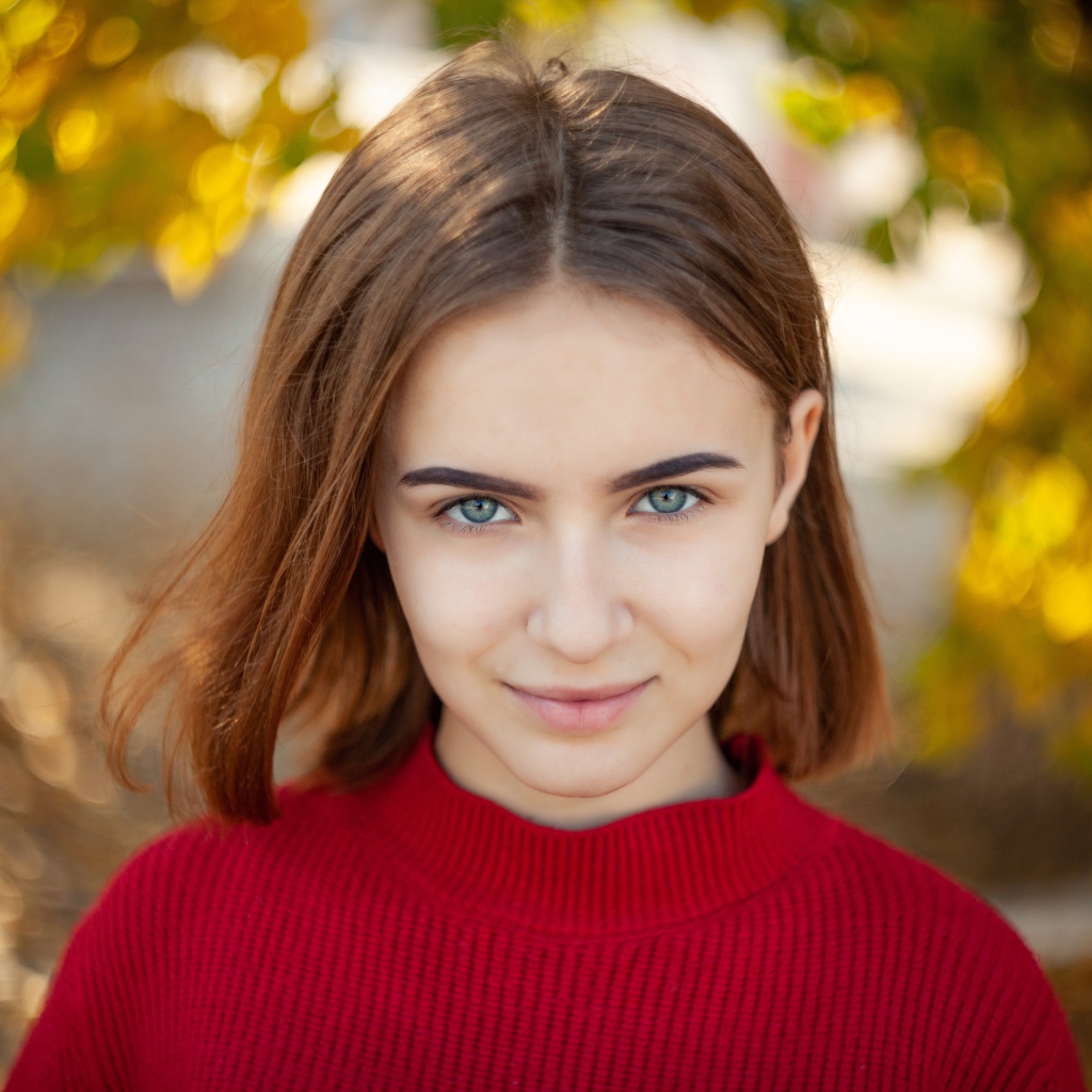 Девушка в красном свитере с короткой стрижкой 