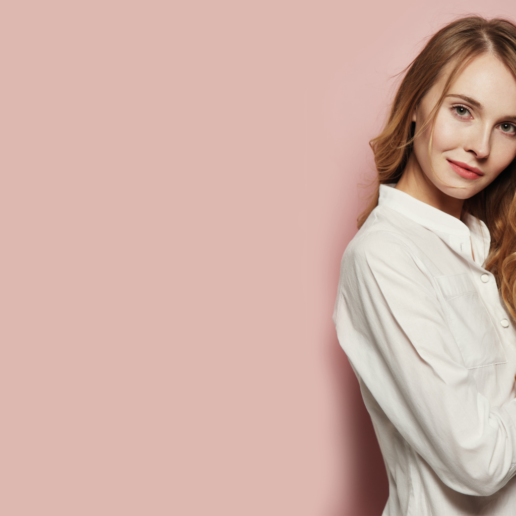 Девушка в белой рубашке на розовом фоне