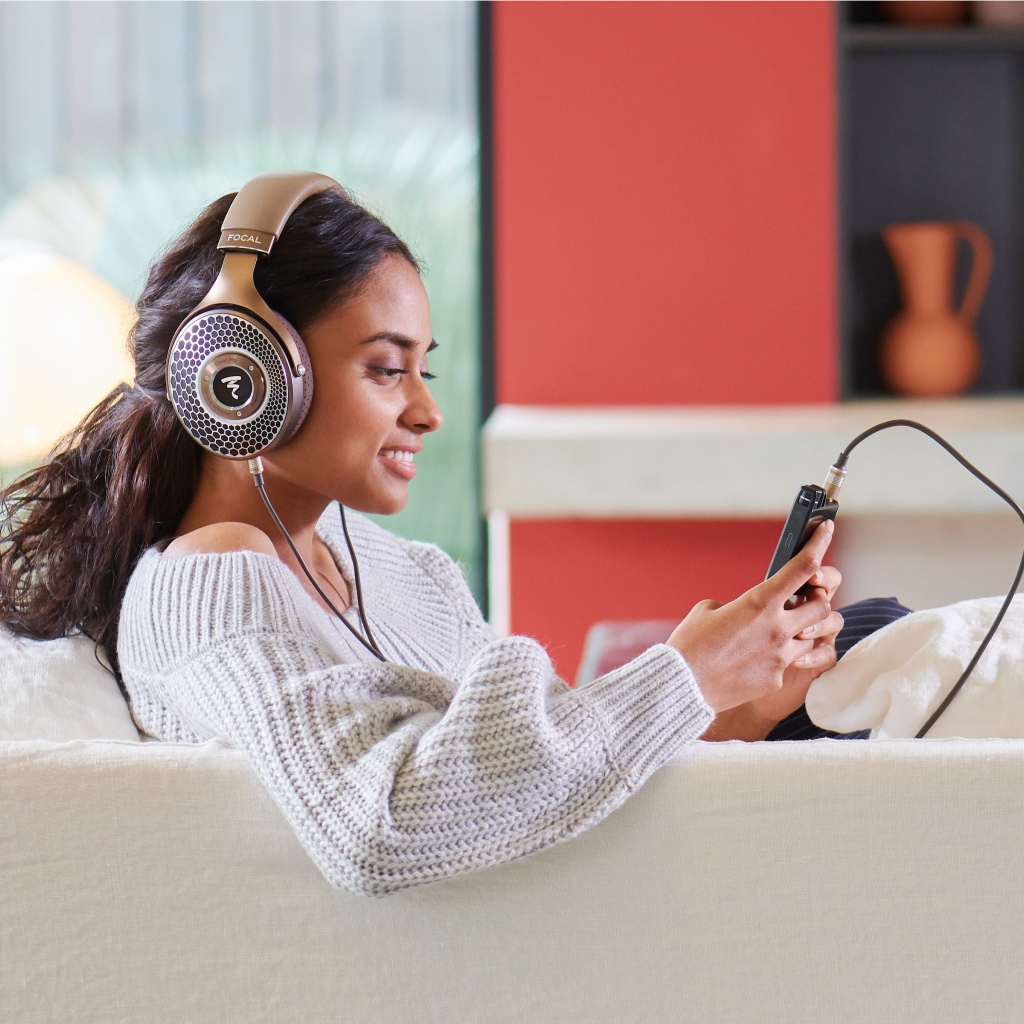 Girl model in headphones on the couch with a player