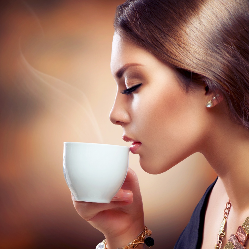 Девушка с закрытыми глазами наслаждается кофе