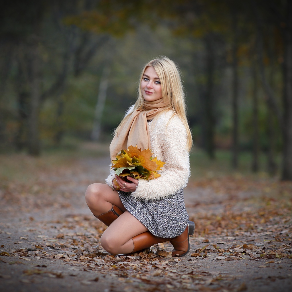 Девушка с листьями на дороге осенью