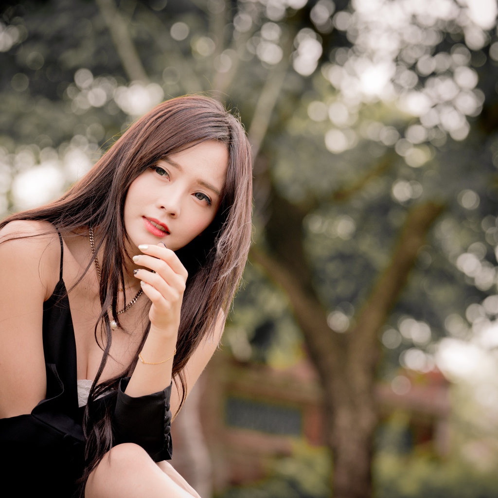 Задумчивая девушка азиатка в черном платье 