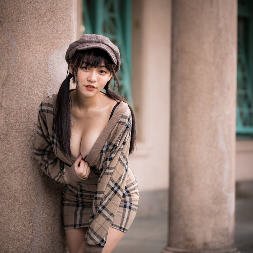 Сексуальная девушка азиатка стоит у колонны 