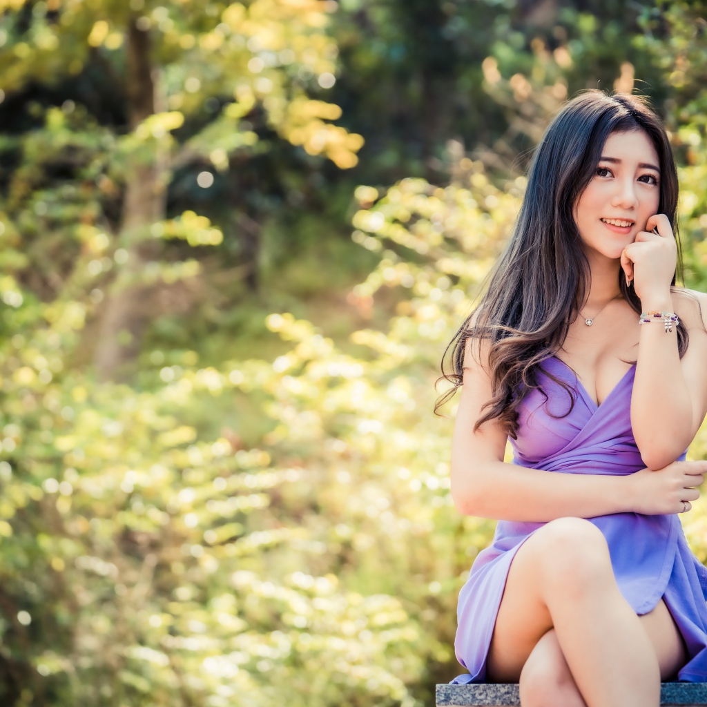 Улыбающаяся девушка азиатка в сиреневом платье