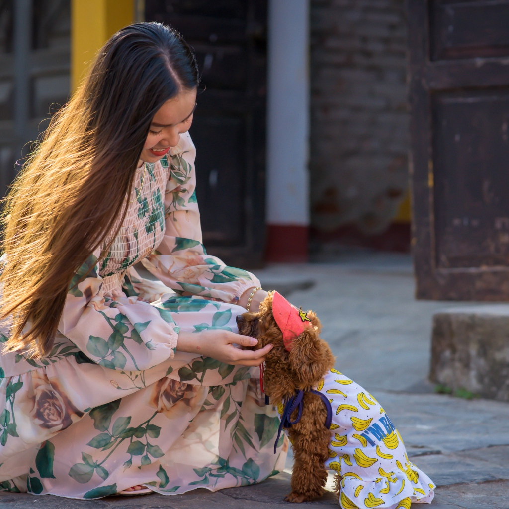 Улыбающаяся девушка азиатка с собакой 