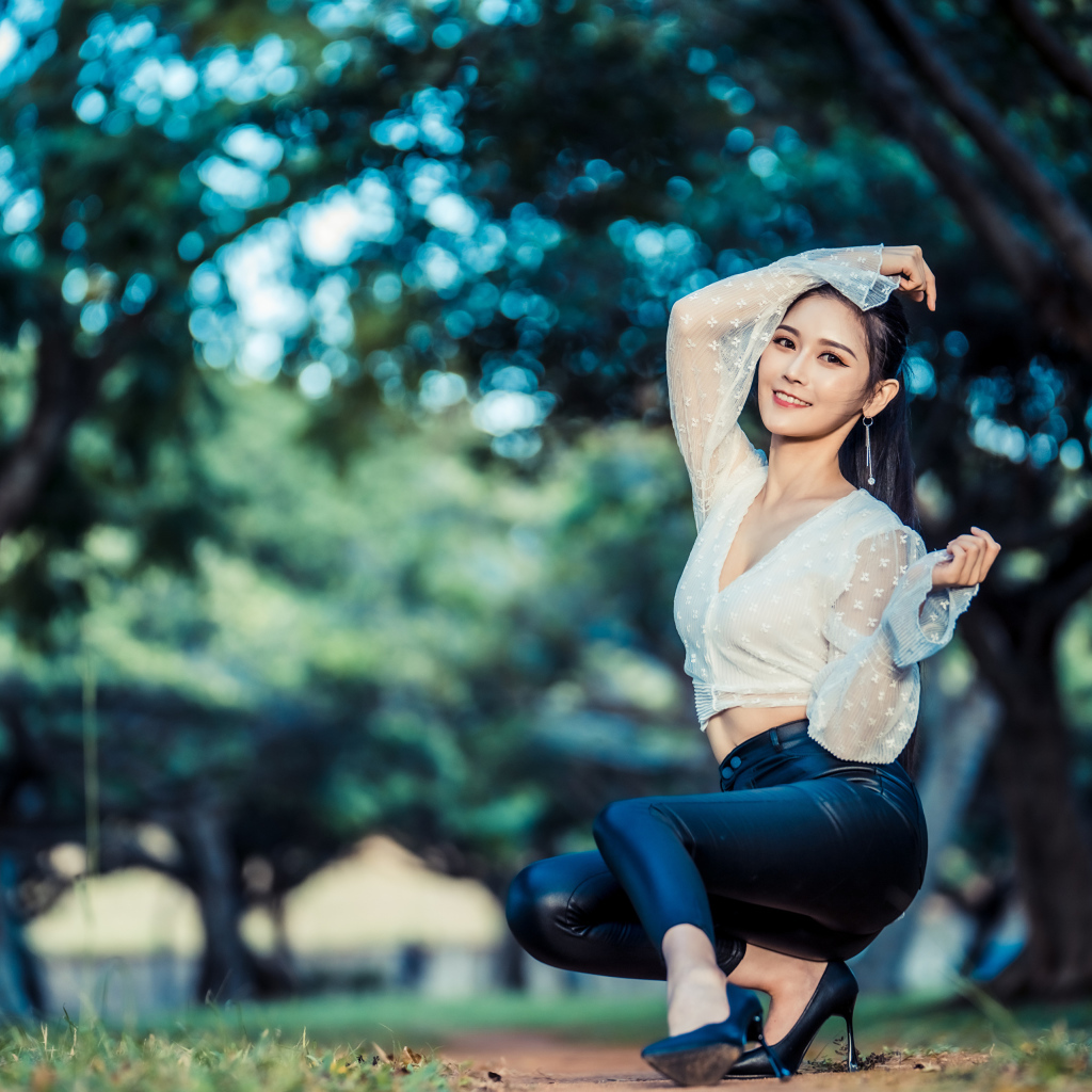 Улыбающаяся азиатка в черных брюках