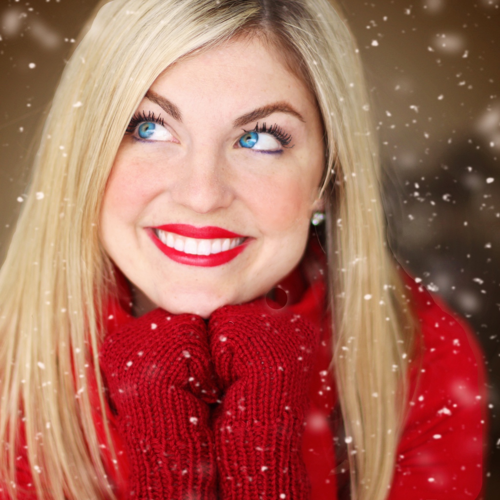 Улыбающаяся голубоглазая девушка в красном свитере 