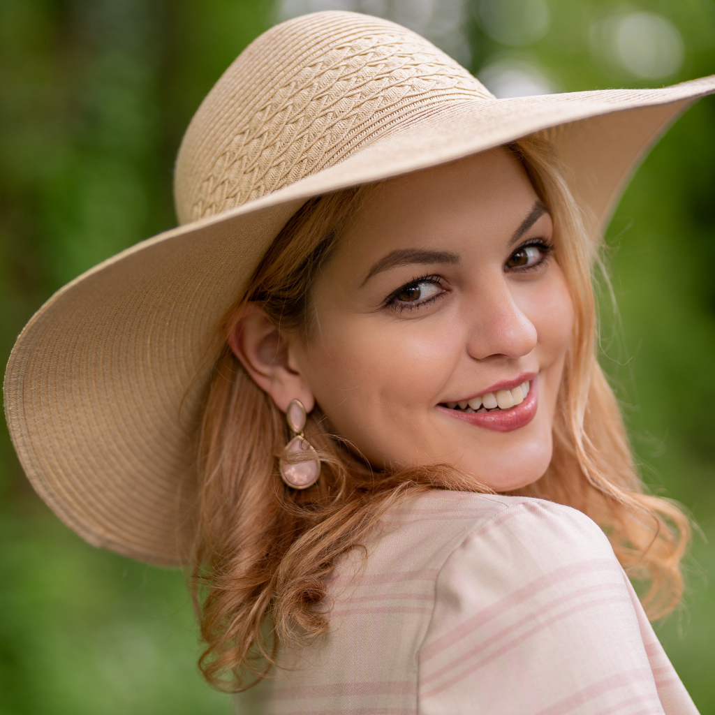 Улыбающаяся кареглазая девушка  в шляпе 