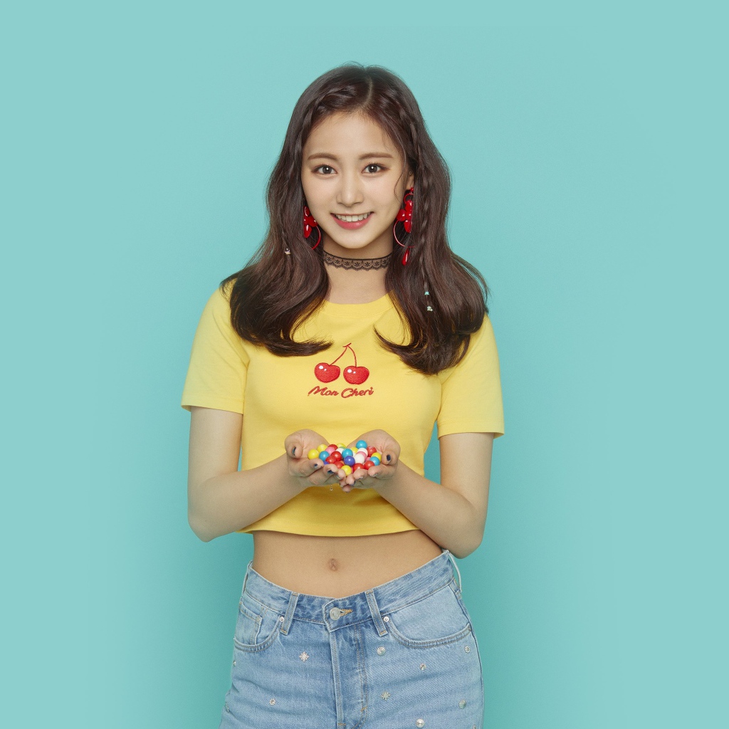 Улыбающаяся девушка с конфетами в ладонях на голубом фоне 