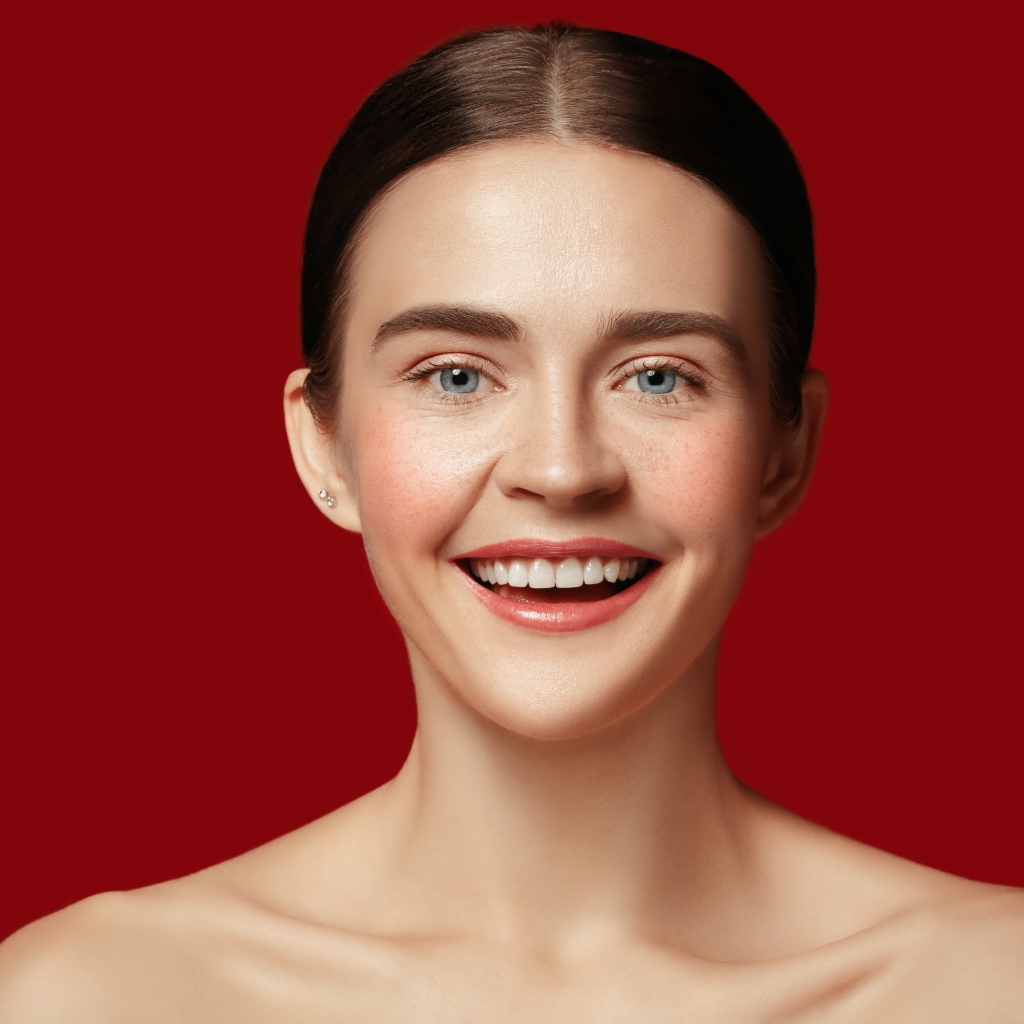 Улыбающаяся молодая девушка на красном фоне