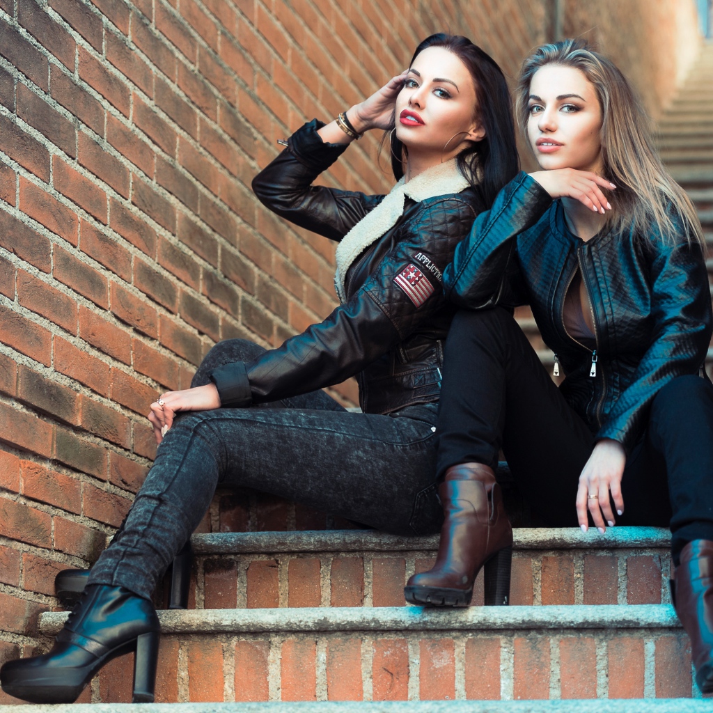 Две красивые девушки сидят на ступенях 