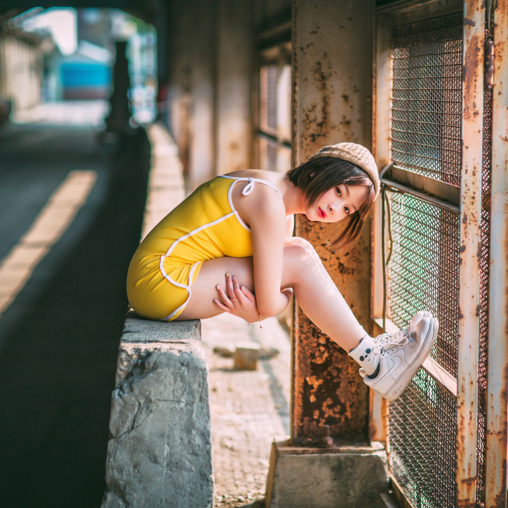 Молодая девушка азиатка сидит у сетки