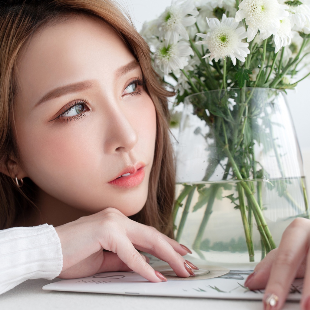 Молодая азиатка с букетом белой хризантемы в вазе