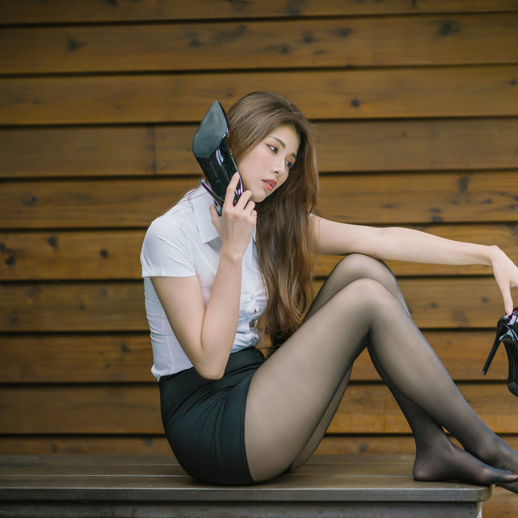 Молодая азиатка с черными туфлями в руках 