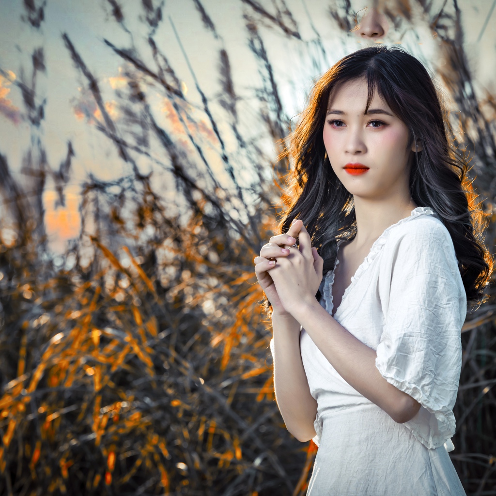 Молодая девушка азиатка в белом платье на закате