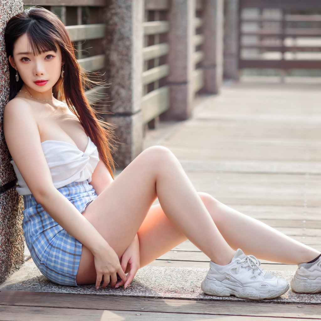 Молодая девушка азиатка в белых кроссовках 