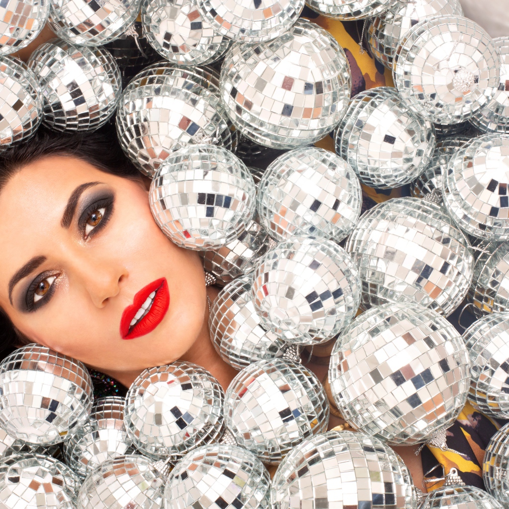 Молодая девушка усыпана блестящими шарами