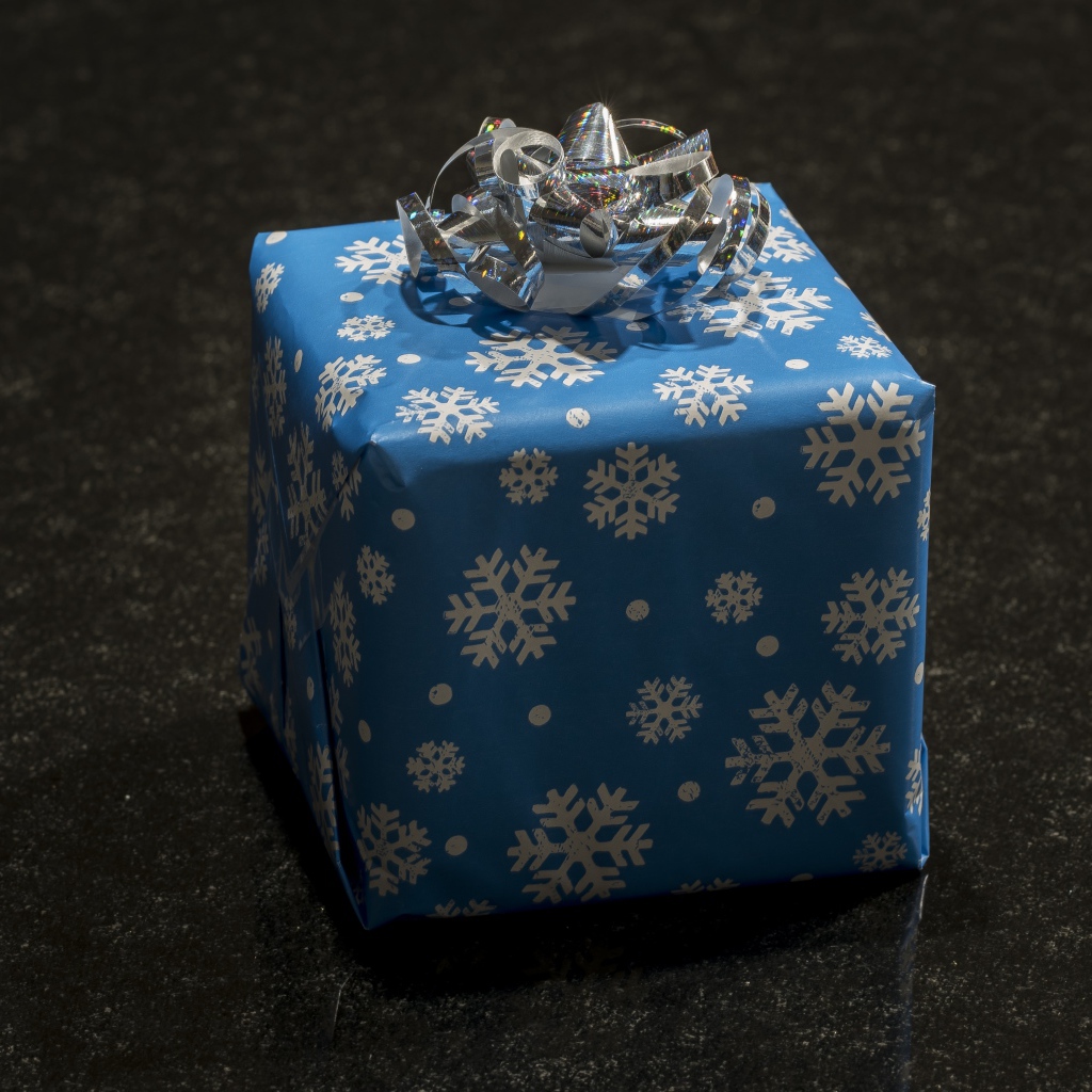 Большой голубой подарок с бантом на черном фоне 