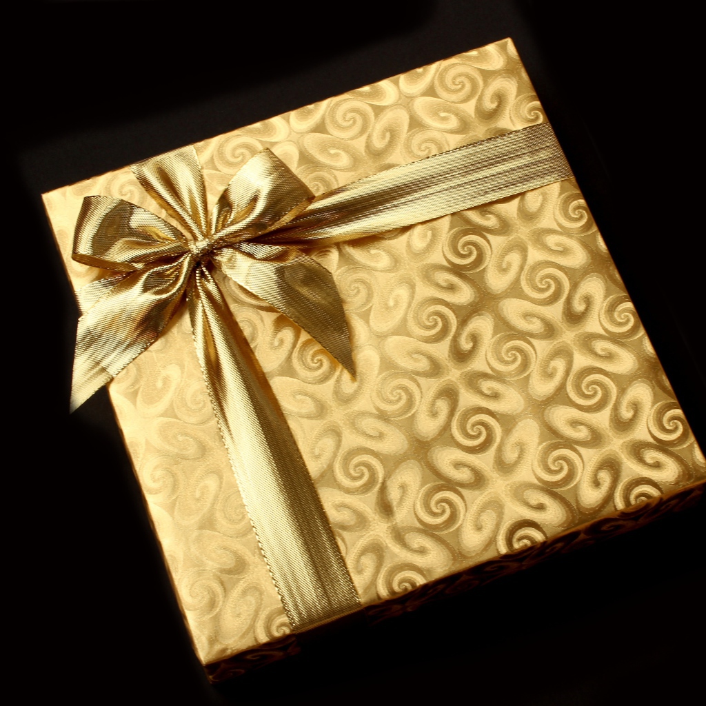 Золотая упаковка с подарком на черном фоне