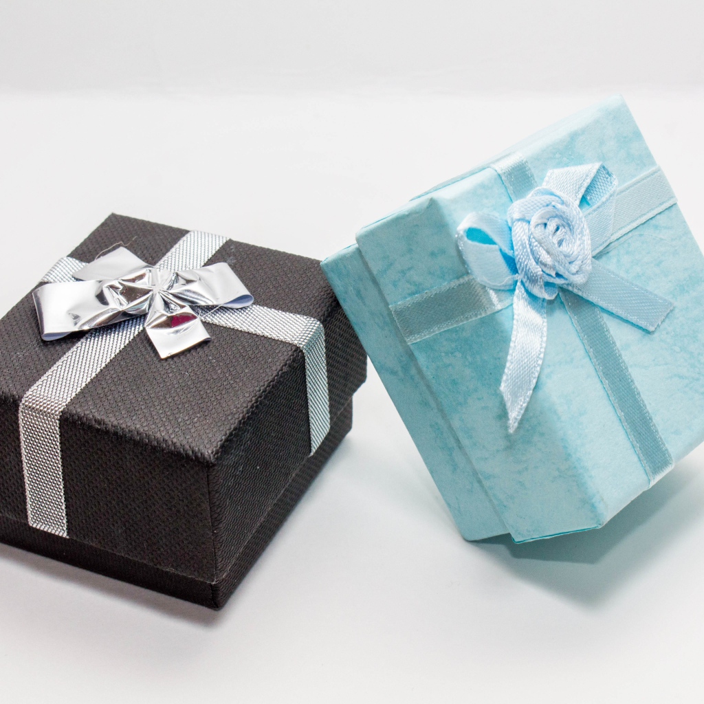 Две коробки с подарками на сером фоне 