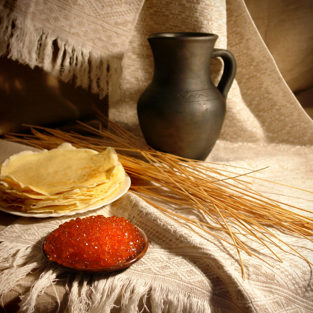 Блины с икрой на столе с колосьями на праздник Масленица