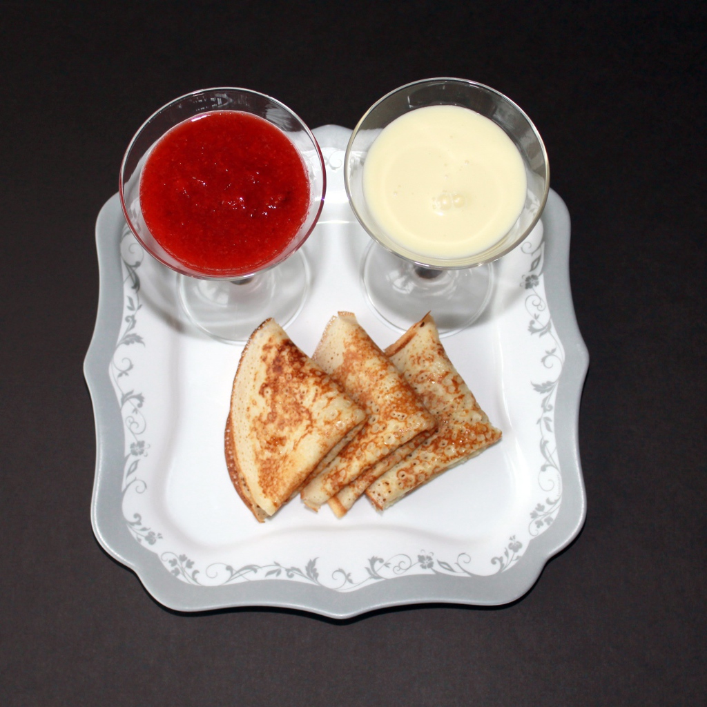 Блинчики с вареньем и сметаной на столе на Масленицу