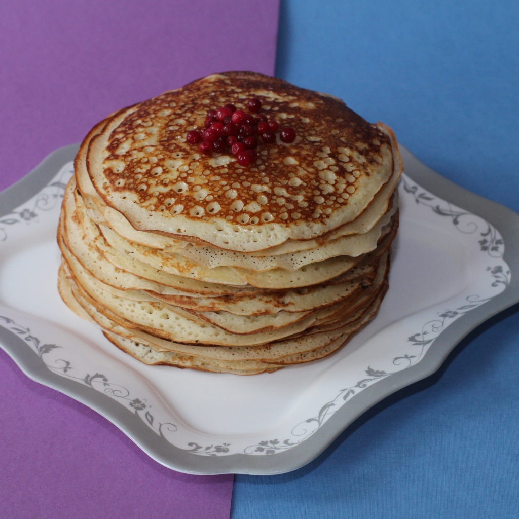 Румяные блины с ягодами на столе на Масленицу