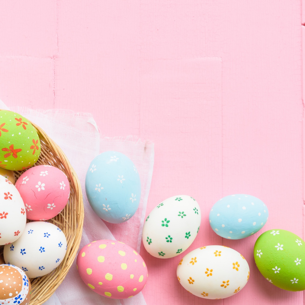 Разноцветные пасхальные яйца на розовом фоне