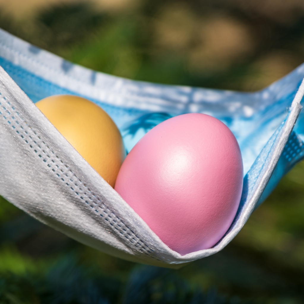 Два крашеных пасхальных яйца в маске от коронавируса