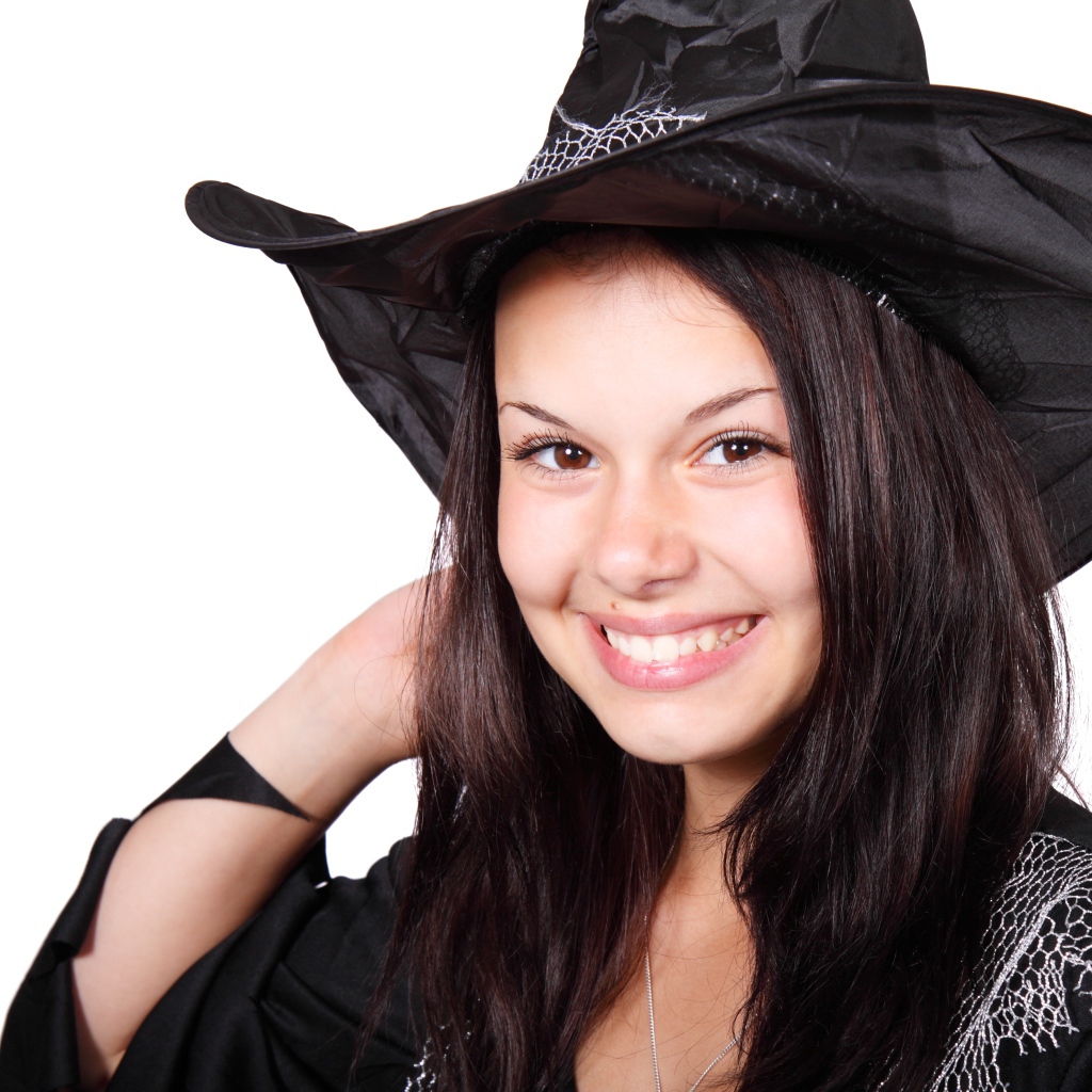 Улыбающаяся девушка в костюме ведьмы на Хэллоуин