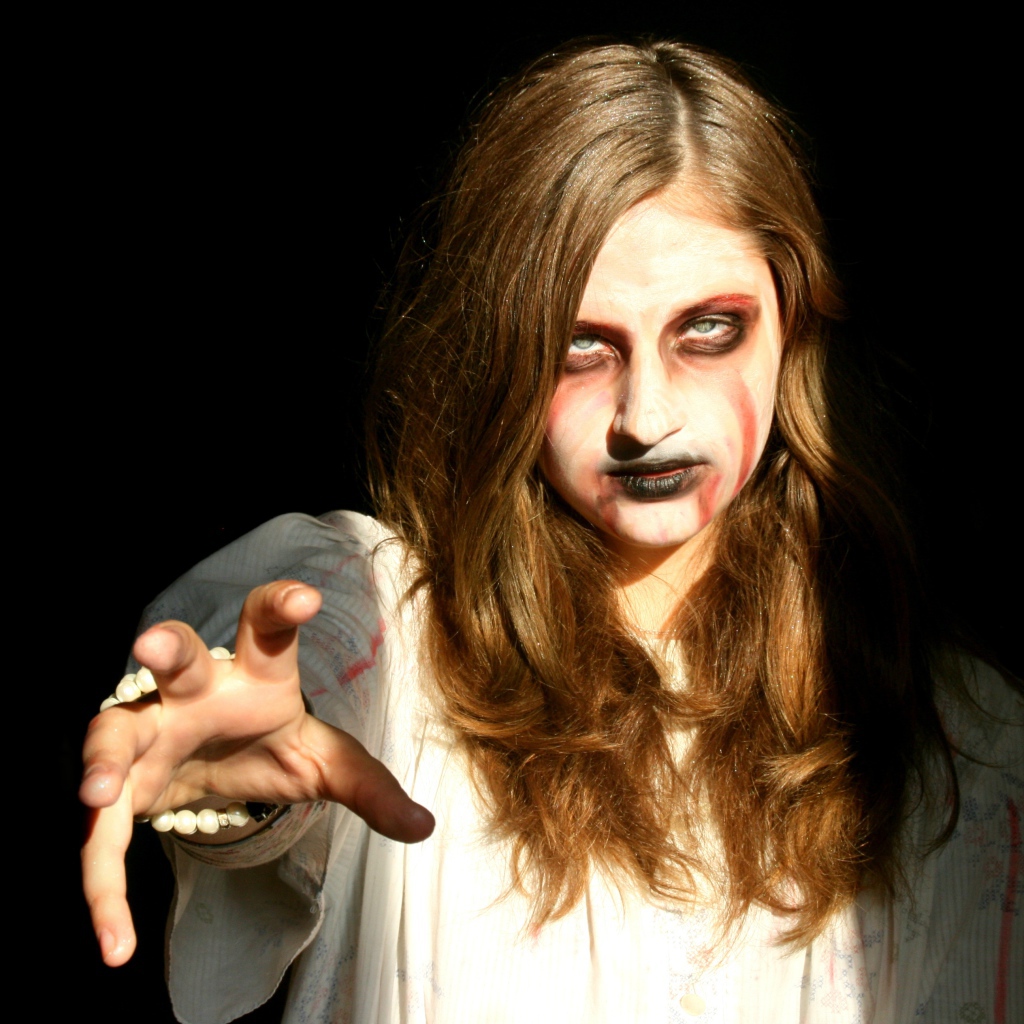 Девушка зомби на черном фоне в костюме на Хэллоуин